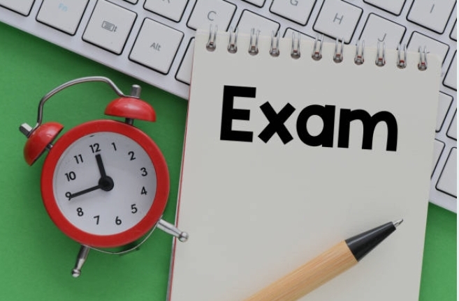 *Conceptual image of a timed exam with an alarm clock beside a notebook labeled "Exam.”*